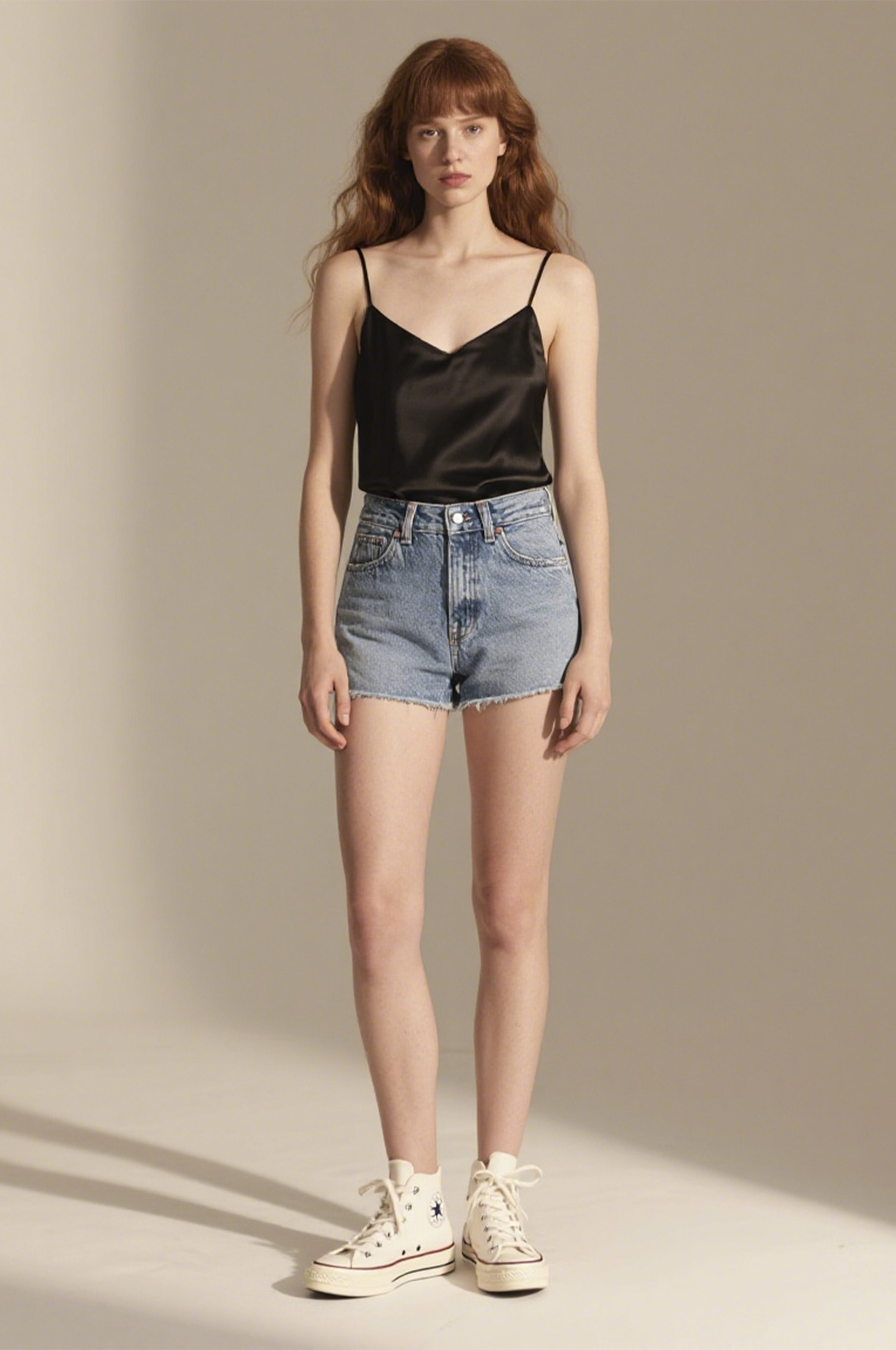 换装前:模特穿黑色吊带背心配牛仔短裤 女模特穿黑色吊带背心和牛仔短裤