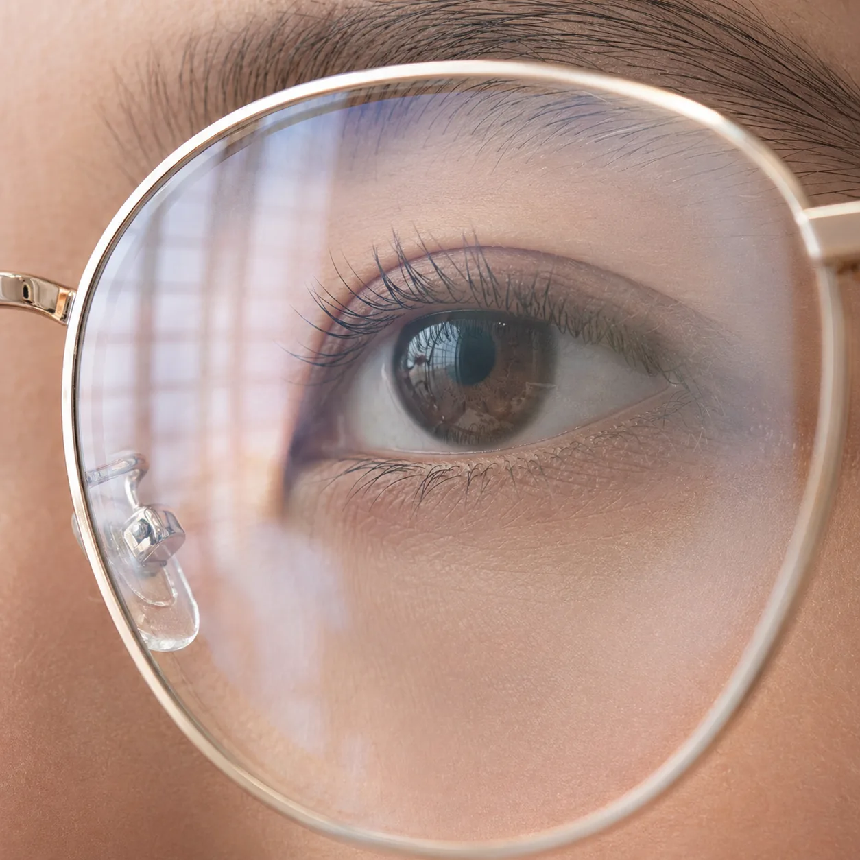 眼镜镜片反光特写宏观摄影，柔和环境反射与镜片后方虹膜轮廓