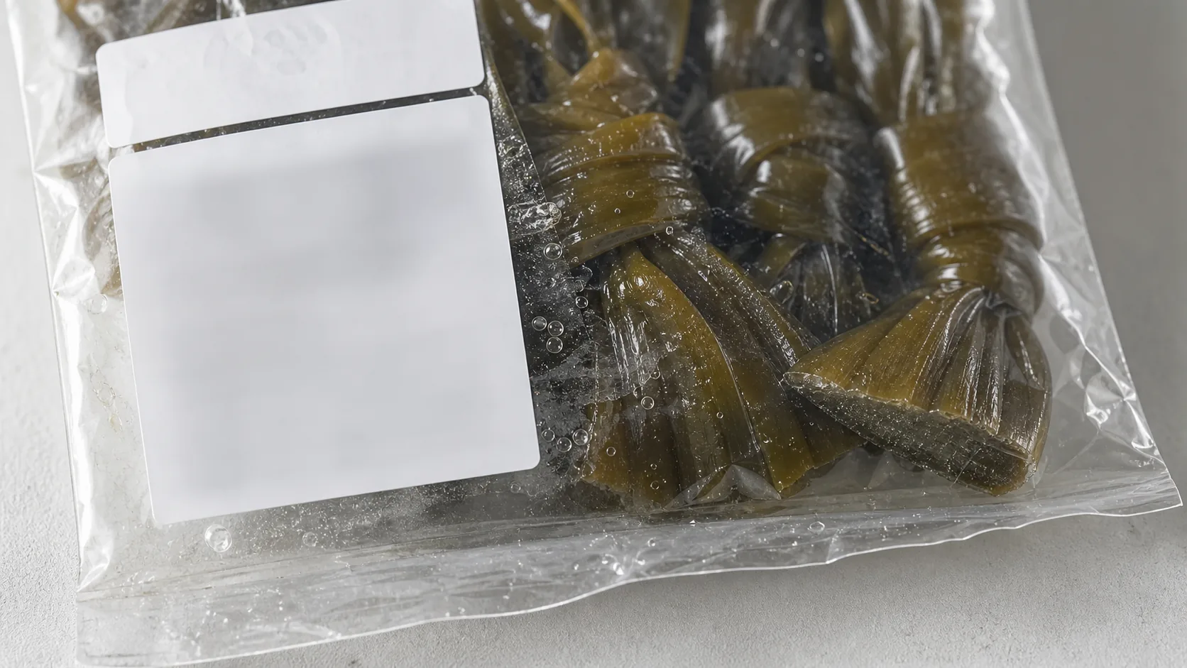 盐渍海带结包装袋盐水痕生产日期区和产地标签的局部特写