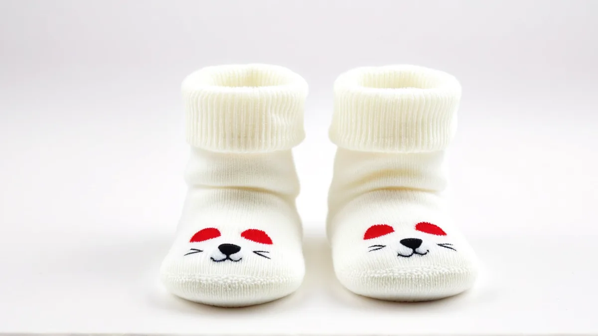 成对摆放的婴儿地板袜产品图，脚底防滑硅胶点与罗纹袜口清晰